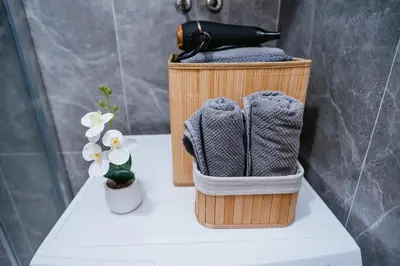 a basket with towels and a hair dryer in a bathroom at Apartment Vukeljic in Doboj