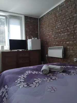 a bedroom with a bed with a purple blanket at AM Rooms in Visoko