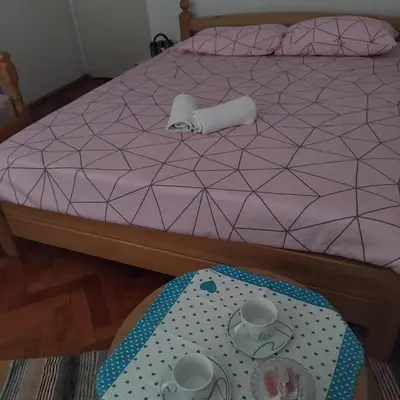 a purple bed with a table in front of it at AM Rooms in Visoko
