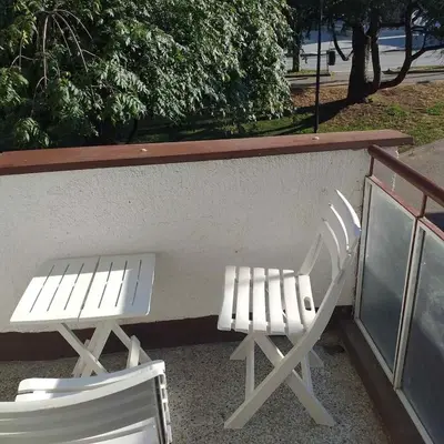 two white chairs sitting next to a wall at AM Rooms in Visoko