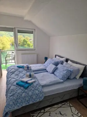 a bedroom with a large bed with towels on it at Apartman Villa E&M in Bihać