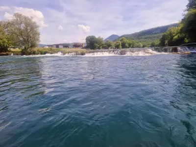 a view of a river with a waterfall in the background at Apartman Villa E&M in Bihać