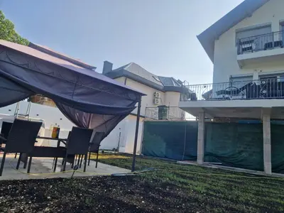 a patio with a table and chairs in front of a house at Apartman Villa E&M in Bihać