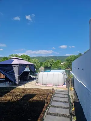 a swimming pool with a tent next to a building at Apartman Villa E&M in Bihać