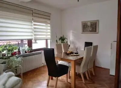 a dining room with a wooden table and white chairs at Apartman Amy Visoko in Visoko