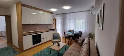 a kitchen and a living room with a couch and a table at Banjaluka Centar1 in Banja Luka