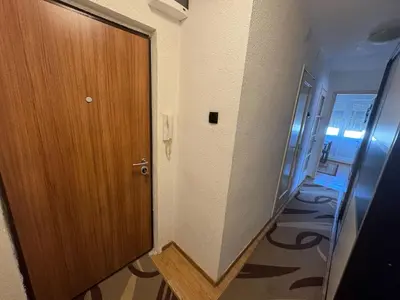 a hallway with a wooden door in a room at Apartment Esmihan in Tuzla