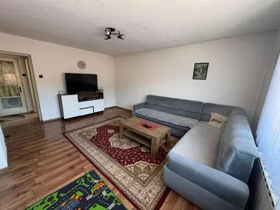 a living room with a blue couch and a table at Apartment Esmihan in Tuzla