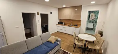 a living room with a couch and a table and a kitchen at VAL apartmani in Jajce