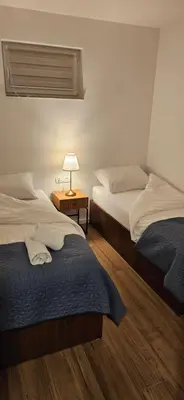 two beds in a room with a lamp on a table at VAL apartmani in Jajce