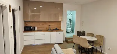 a kitchen with a sink and a table with chairs at VAL apartmani in Jajce