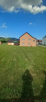 a large grass field with a building in the background at Apartmani Donji Vakuf in Donji Vakuf