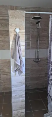 a shower with a glass door with a towel at Apartmani Donji Vakuf in Donji Vakuf