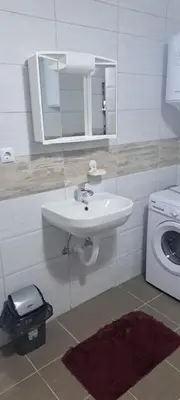 a bathroom with a sink and a washing machine at Apartmani Donji Vakuf in Donji Vakuf