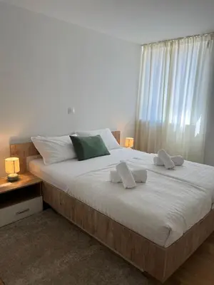 a bedroom with a large bed with two towels on it at Apartmani Pervan in Livno