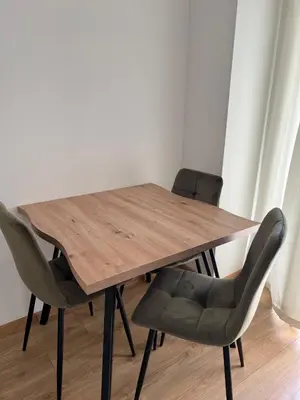 a wooden table and two chairs in a room at Apartmani Pervan in Livno