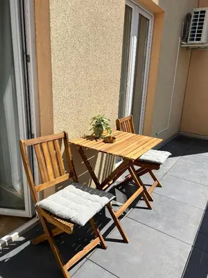 a wooden table and two chairs on a balcony at Apartmani Pervan in Livno