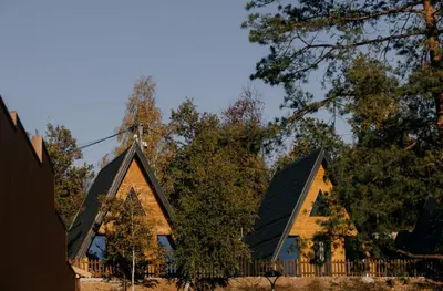 a house with a black roof and some trees at Kraljičini konaci in Doboj