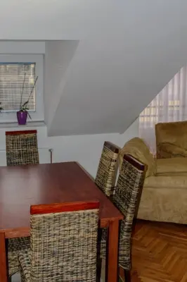 a dining room with a table and chairs and a couch at La Casa in Prijedor