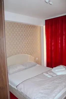 a bedroom with a bed with a red curtain at La Casa in Prijedor