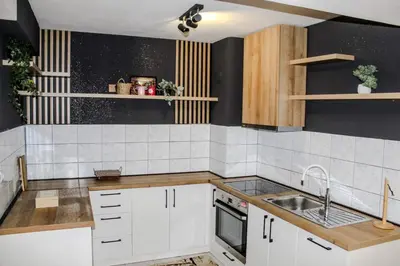 a kitchen with white cabinets and a sink at La Casa in Prijedor