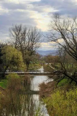a view of a river with a bridge and trees at La Casa in Prijedor