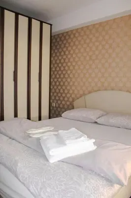 a white bed with two folded towels on it at La Casa in Prijedor