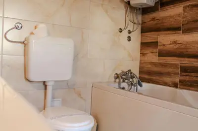 a bathroom with a toilet and a bath tub at La Casa in Prijedor