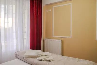 a bedroom with a bed with a red curtain and a window at La Casa in Prijedor