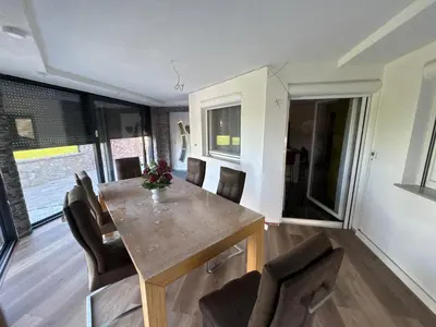 a dining room with a wooden table and chairs at Villa Amy in Bihać