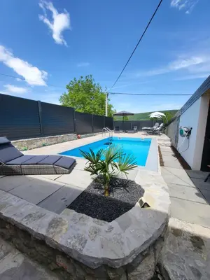 a swimming pool with two lounge chairs next to a house at Villa Amy in Bihać