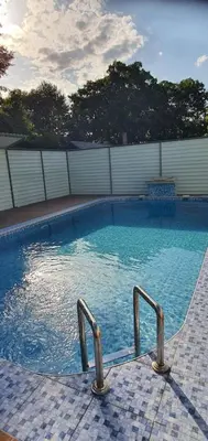 a swimming pool with blue water and metal rails at Weekend house Mali Raj in Visoko