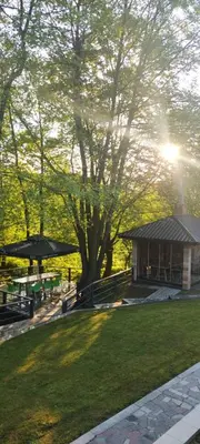 a park with benches and a building and a tree at Weekend house Mali Raj in Visoko
