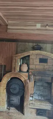 a stone oven in a room with a wooden ceiling at Weekend house Mali Raj in Visoko
