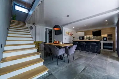 a kitchen and dining room with stairs and a table and chairs at Villa Imperio Deluxe in Brekovica