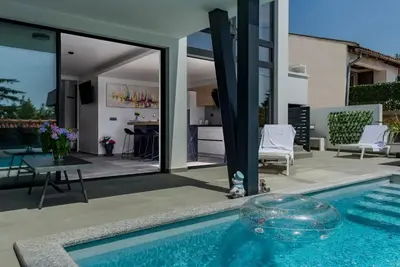a house with a swimming pool and a patio at Villa Imperio Deluxe in Brekovica