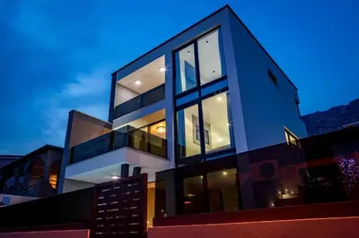 a building with large glass windows at dusk at Villa Imperio Deluxe in Brekovica