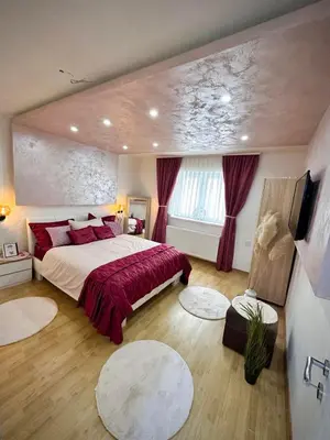 a bedroom with a large bed with red pillows at Apartman TEA in Željeznička Stanica Bosanski Šamac