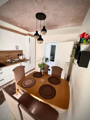 a kitchen with a wooden table and chairs in a room at Apartman TEA in Željeznička Stanica Bosanski Šamac