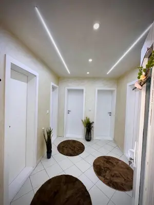 a room with three white doors and brown rugs at Apartman TEA in Željeznička Stanica Bosanski Šamac