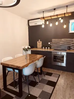 a kitchen with a wooden table and white chairs at Vikendica Niki - Village house with pool in Ćetojevići