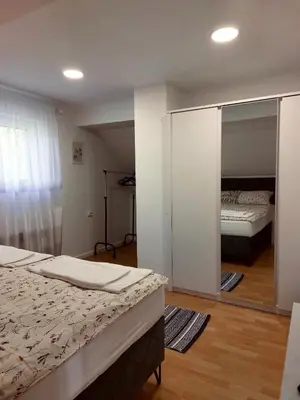 a bedroom with two beds and a mirror at Vikendica Niki - Village house with pool in Ćetojevići