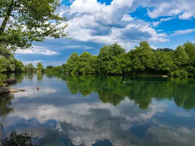 a river with trees and clouds in the water at UNA Escape in Glodina