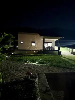 a house lit up at night with a hose at UNA Escape in Glodina