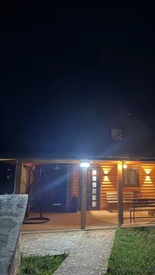 a house at night with a bench and lights at Log Cabin Plavšić - Vikendica Plavšić in Šipovo