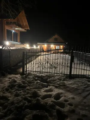 a fence covered in snow in front of a house at Log Cabin Plavšić - Vikendica Plavšić in Šipovo