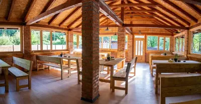 a dining room with tables and chairs and windows at Una Olympic House in Lilaci