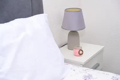 a lamp on a night stand next to a bed at Ćato s cottage in Bravnice