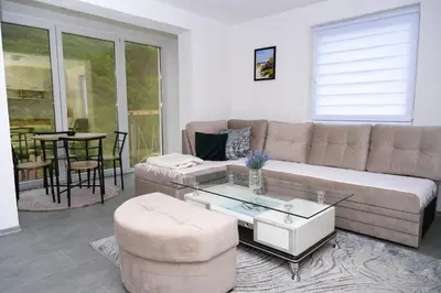 a living room with a couch and a table at Ćato s cottage in Bravnice