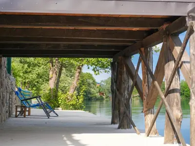 a blue bench sitting under a bridge next to the water at Ranch Una Soul in Glodina